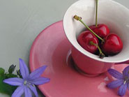 Tasse rose contenant des cerises