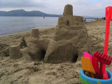 Château de sable et seau en plastique